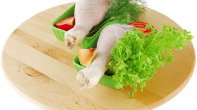 Chicken legs meat greens vegetables small board white background 4k wallpaper