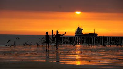 beach promenade bridge sea sunset waves children birds 4k wallpaper