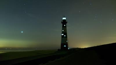 Lighthouse glow night 4k wallpaper