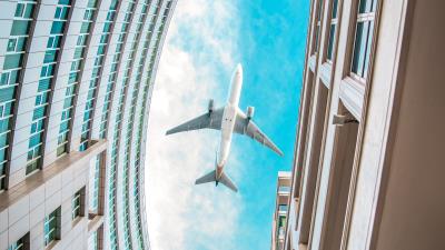 Buildings plane sky 4k wallpaper