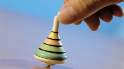 Hand spinning top toy blue backgroun 4k wallpaper