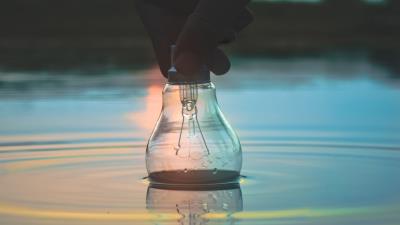 Light bulb hand water 4k wallpaper