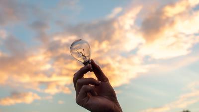 Lightbulb hand sky 4k wallpaper