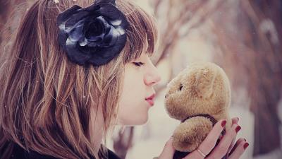 Girl kissing a teddy bear out in the snow 8k wallpaper