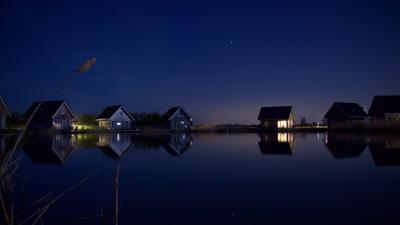 houses at lake water starry night 4k ve wallpaper